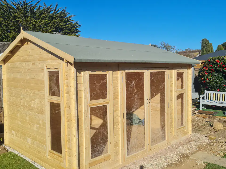 Timber garden room on a levelled base in a sunny garden