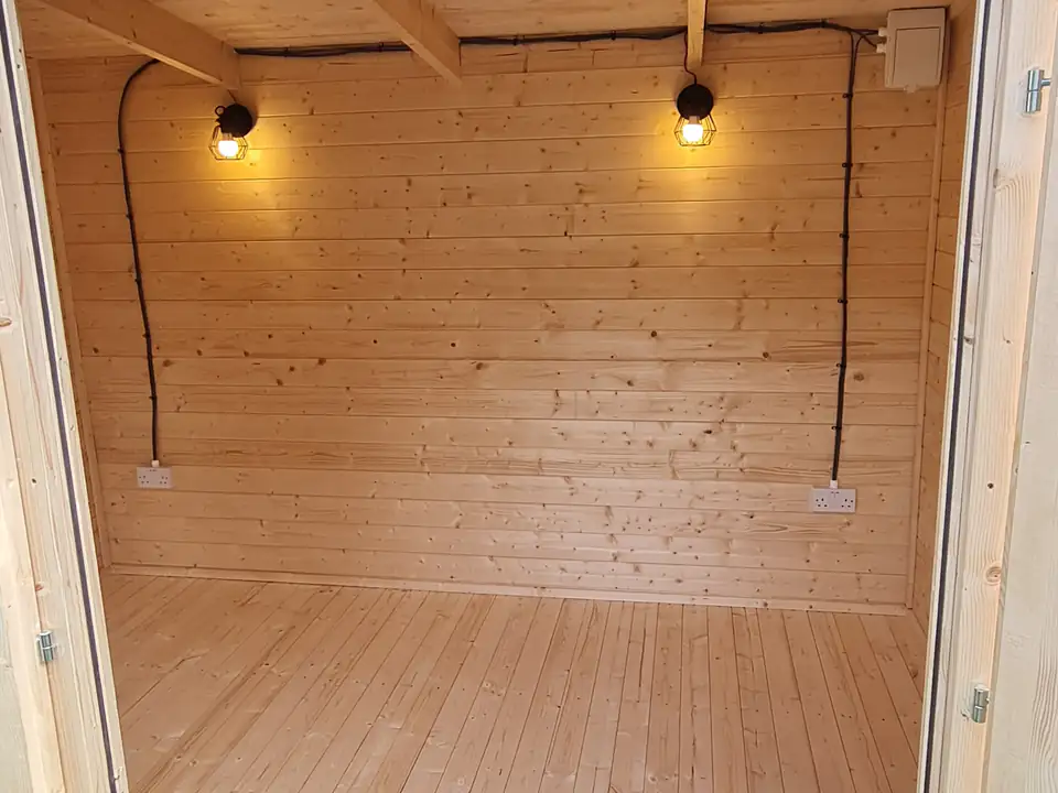 Inside a garden room with lighting and timber-lined walls