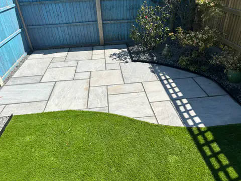 Porcelain patio with a curved edge against a new lawn