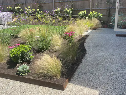 Ornamental grasses and perennials beside a resin-bound path