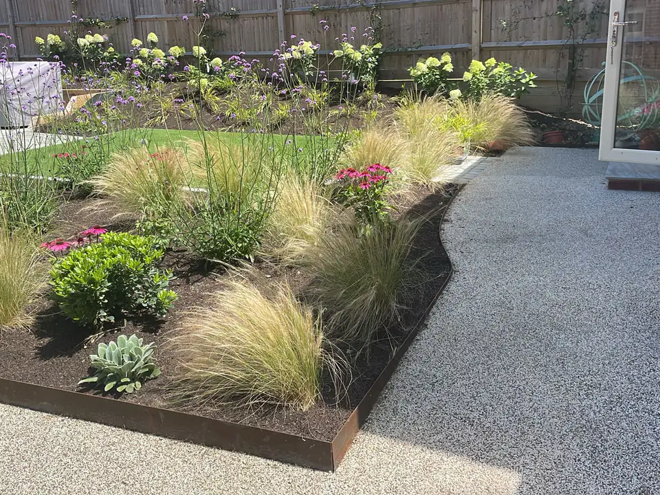 Ornamental grasses and perennials beside a resin-bound path